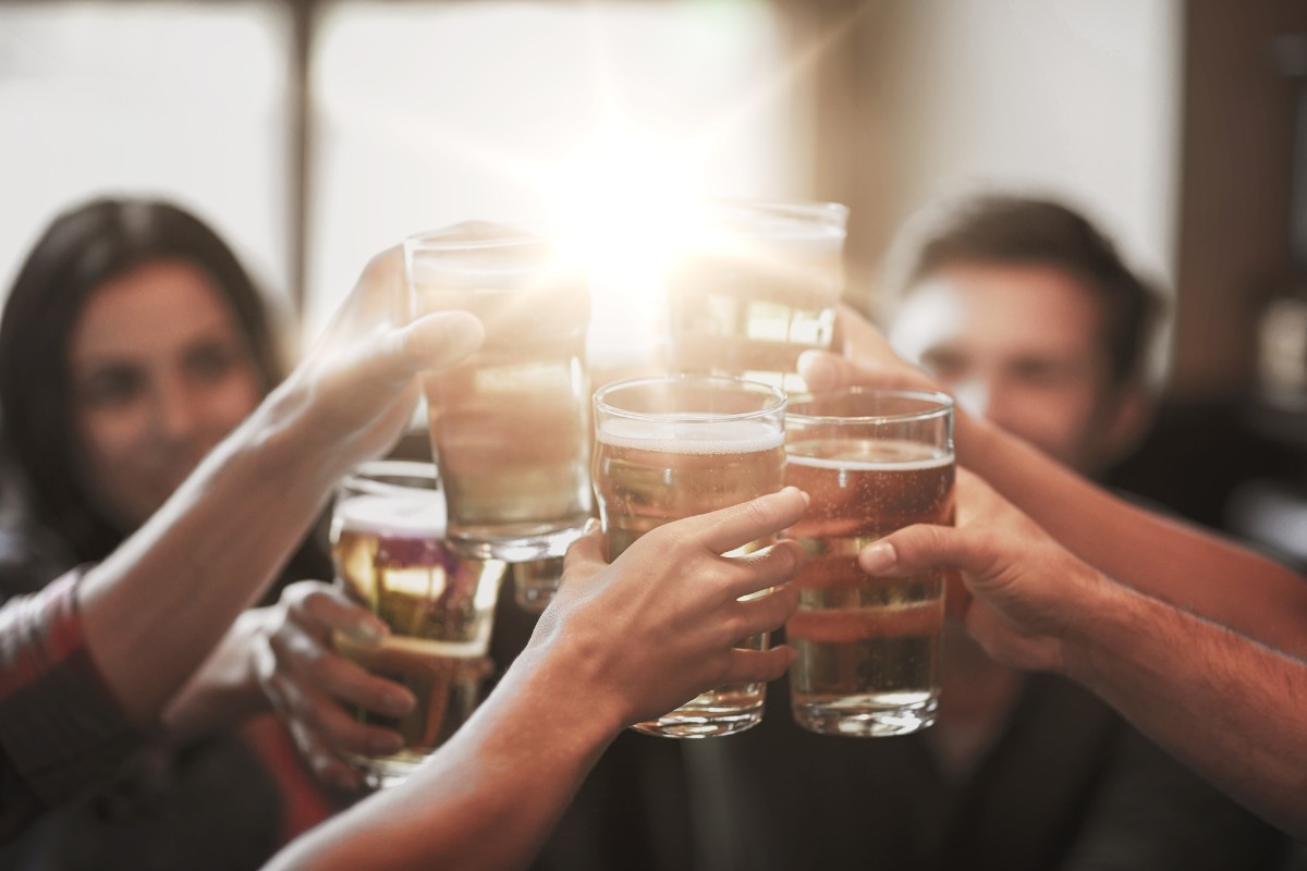 Grupo de amigos brindando com bebidas alcoólicas, mostrando como consumir com equilíbrio.