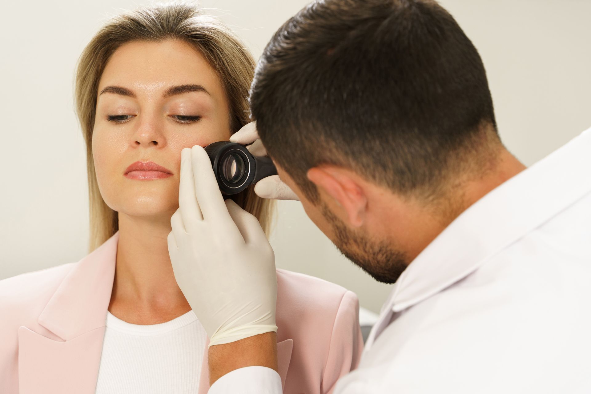 Paciente sendo examinada por dermatologista com dermatoscopia para diagnóstico de doenças de pele