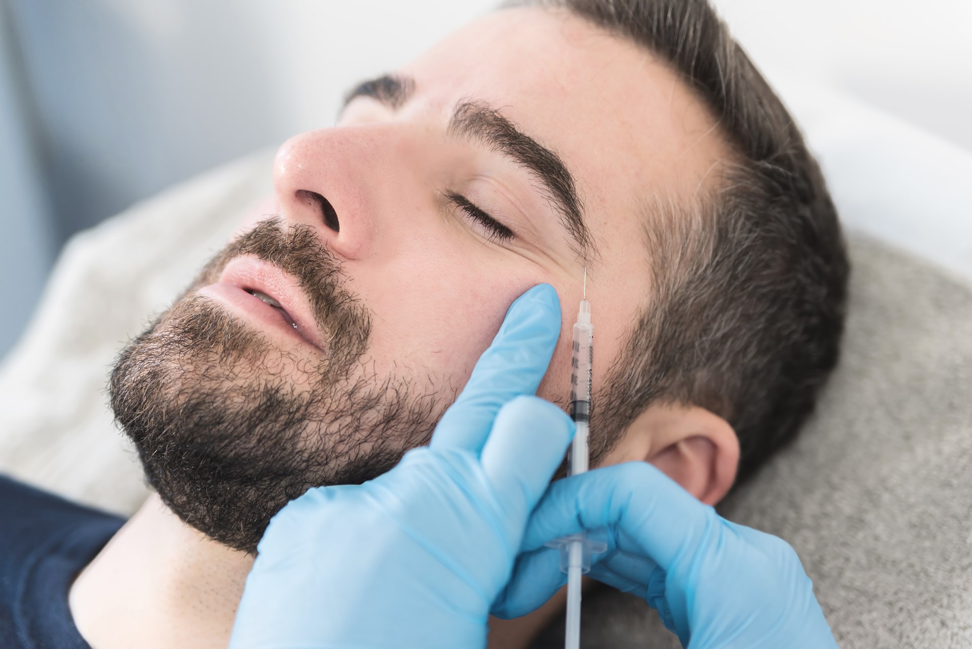 Homem fazendo procedimento facial com toxina botulínica em clínica de dermatologia e estética